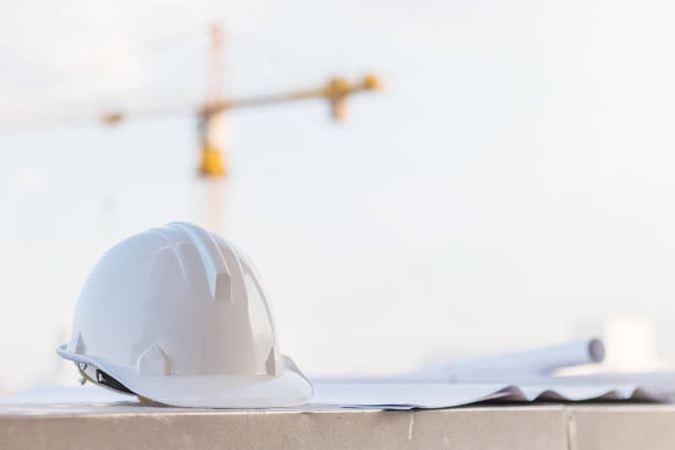 istock The white safety helmet at construction site with crane background 926518148