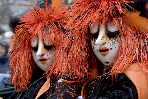 Menton, France-February 12, 2023: group of women dressed colorful carnival costumes red Indian wearing traditional dress with color feathers on head marching during carnival parade of Lemon Festival