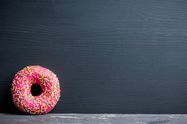istock Donuts with sprinkles on the rustic wooden background 926520758