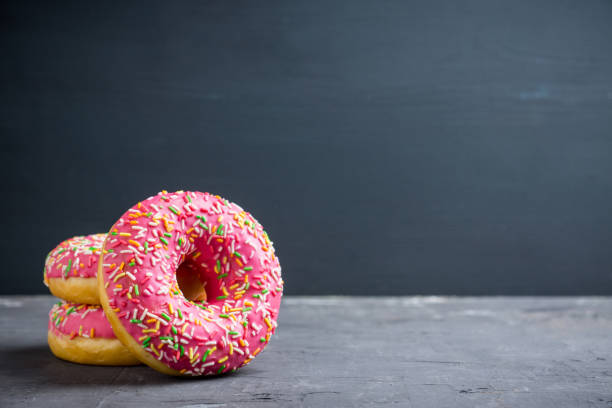 istock Donuts with sprinkles on the rustic wooden background 926520762