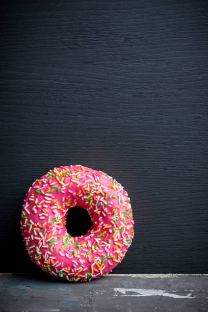istock Donuts with sprinkles on the rustic wooden background 926520794