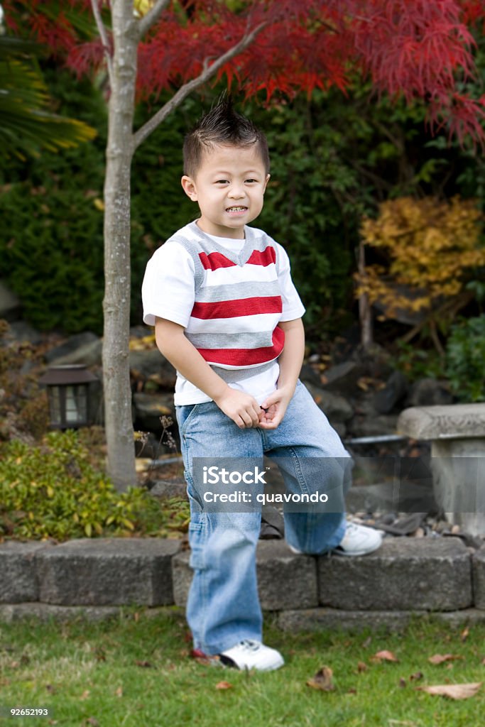 Petit garçon asiatique avec Mohawk dans le jardin, espace de copie - Photo de Coiffure punk libre de droits
