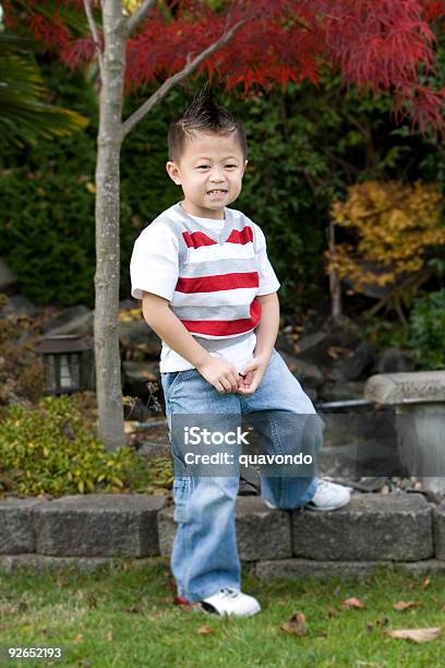 Photo libre de droit de Petit Garçon Asiatique Avec Mohawk Dans Le Jardin Espace De Copie banque d'images et plus d'images libres de droit de Coiffure punk