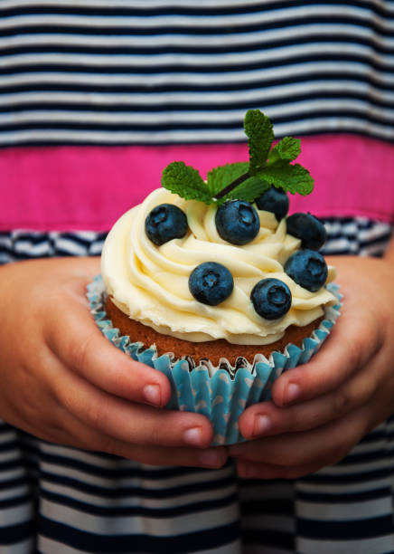 istock Little girl holding cupcake 926526058