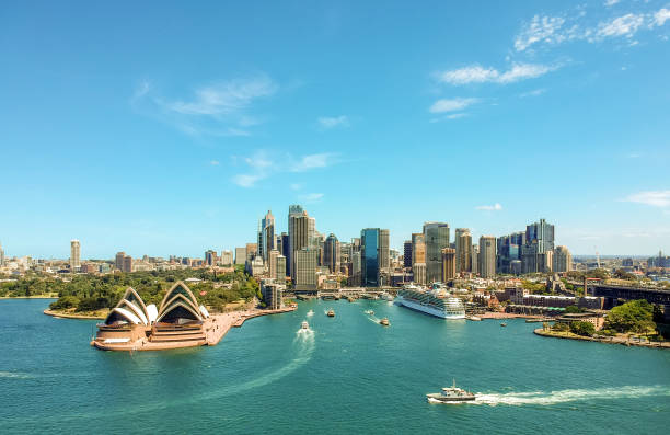 atemberaubende luftaufnahmen drohne weitwinkelaufnahme des sydney harbour mit dem opernhaus, ein kreuzfahrtschiff und viele hochhäuser im hintergrund. in der nähe von vorort kirribilli genommen. new south wales, australien. - sydney opera house stock-fotos und bilder