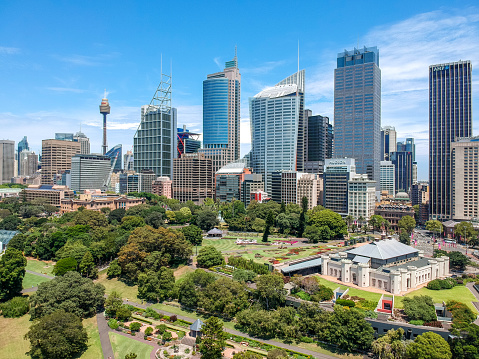 Stunning drone aerial wide angle view of the city of Sydney and its skyscrapers shot from above the Royal Botanical Gardens. Sydney Conservatorium of Music on the right.