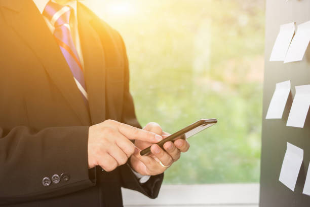 istock man's hands using smartphone in interior, Executive businessman busy with tablets at modern office,young male student typing SMS text message on mobile phone in a cafe,flip card on board,vintage color 926530444