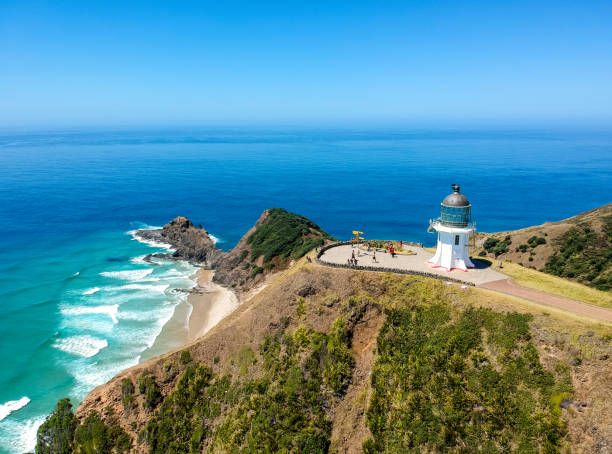 Stunning wide angle aerial drone view of Cape Reinga Lighthouse at Cape Reinga, the northernmost point of the North Island of New Zealand. The lighthouse is a famous tourist attraction. stock photo