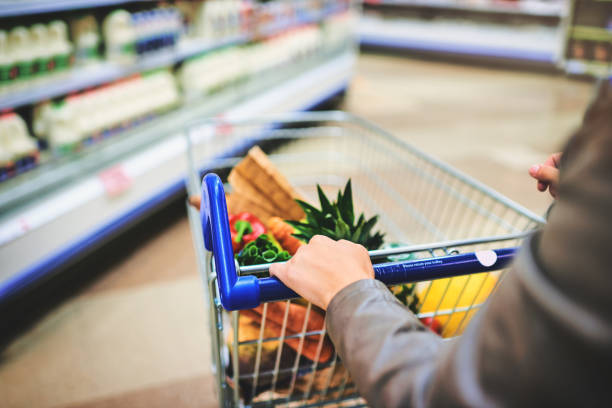 Cropped shot of a woman pushing a trolley while shopping at a grocery store