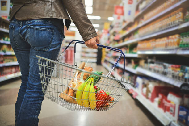 Must stock up Cropped shot of a woman holding a basket while shopping at a grocery store holding shopping basket stock pictures, royalty-free photos & images