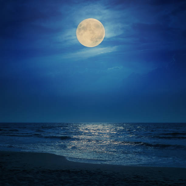 super moon in clouds over sea super moon in clouds over sea fantasy moonlight beach stock pictures, royalty-free photos & images