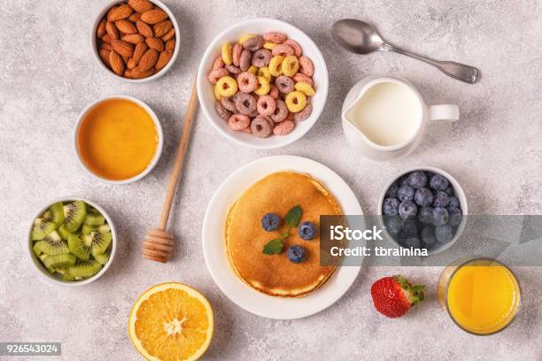 Breakfast With Colorful Cereal Rings Pancakes Fruit Milk Juice Stock Photo - Download Image Now