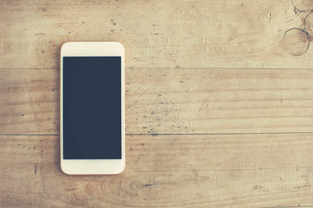 istock White mobile phone on wooden background 926551234