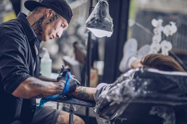 istock Girl getting arm tattoo 926563082
