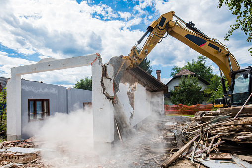 Mechanical digger demolishing building.