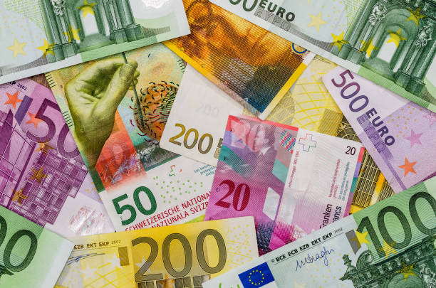 euro y dinero de franco suizo como fondo - swiss francs swiss currency switzerland finance fotografías e imágenes de stock