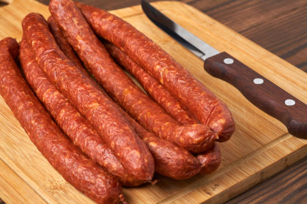 istock Thin smoked sausage on a wooden background. Close-up. 926563850