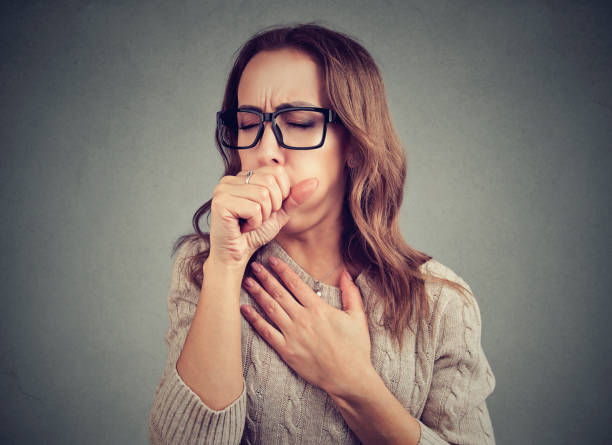 Sick woman coughing with pain Young woman having asthma problems and coughing badly covering mouth and holding hand on chest. coughing photos stock pictures, royalty-free photos & images