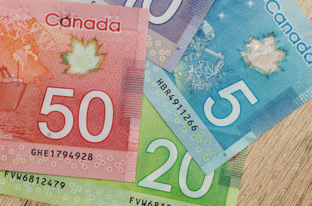 kanadischer dollar-scheine auf tisch hautnah - canadian currency stock-fotos und bilder