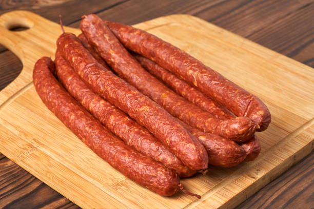 istock Thin smoked sausage on a wooden background. Close-up. 926566778