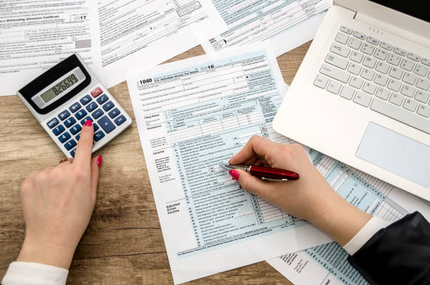 istock Tax form 1040 human hands and laptop 926566854