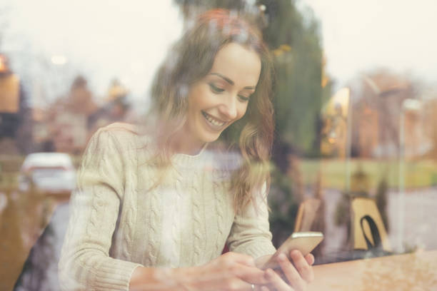 istock Cheerful woman using phone in cafe 926567062
