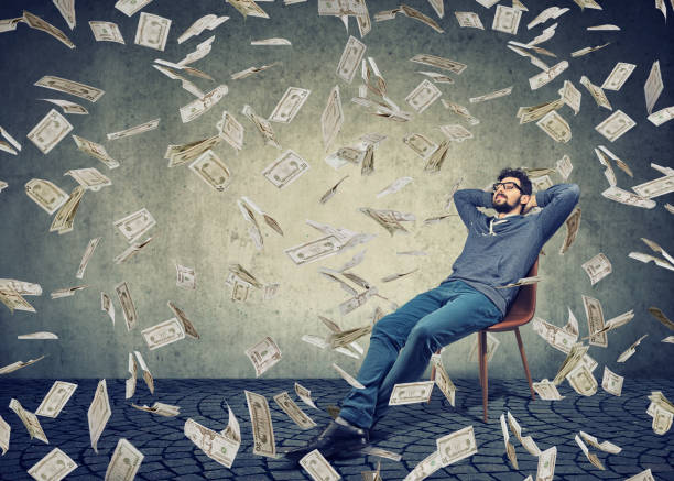 istock Successful man sitting among flying money 926567850