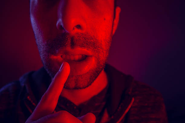 istock Man with seductive facial expression holding finger on mouth 926570798