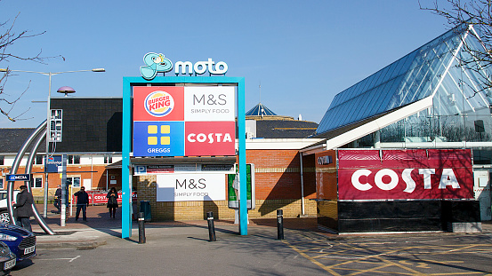 Reading, UK: February 24, 2018: Reading Motorway Services is a three burger rated service area on the M4 operated by Moto. Panoramic with blue sky background.