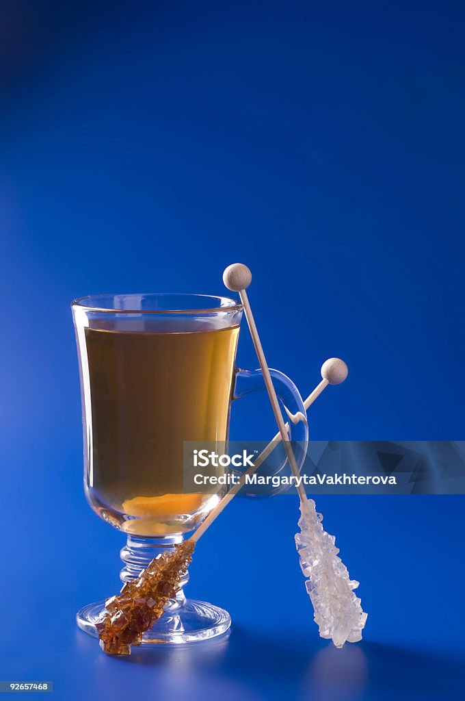 Tazza da tè con caramello di canna da zucchero in sfondo blu. - Foto stock royalty-free di Alimentazione sana