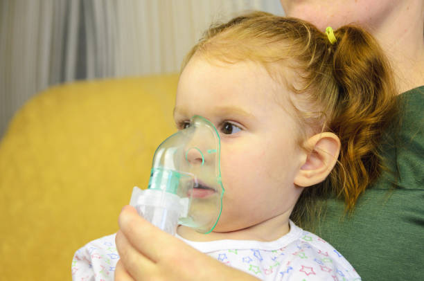 istock Woman with young child doing inhalation with a nebulizer. 926578474