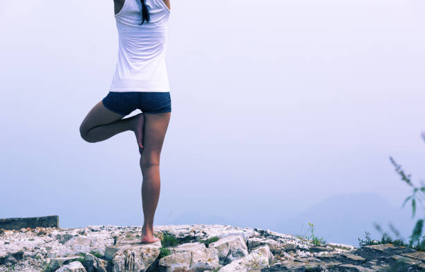 istock One woman practicing yoga at mountain peak 926578884
