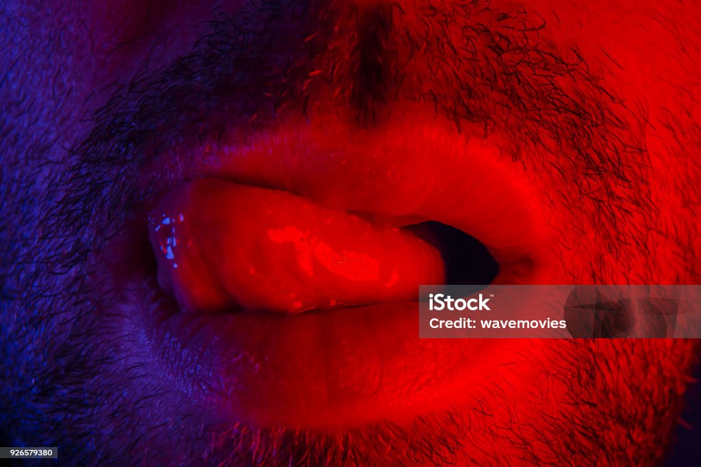Macro de cerca al hombre con expresión facial seductor su lengua lamiendo sus labios - Foto de stock de Hombres libre de derechos