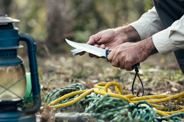 man hands sharpening knife outdoors in the wilderness - putty knife imagens e fotografias de stock