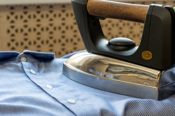 istock The iron strokes the man's blue shirt. 926583816