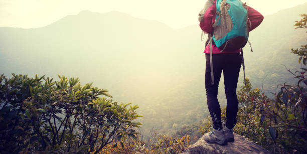istock woman backpacker looking at the view on mountain top cliff edge 926586296
