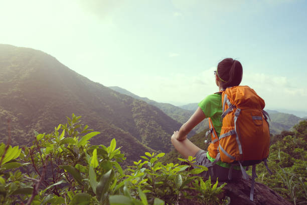 istock Woman backpacker sit on mountain peak cliff edge enjoying view 926586428