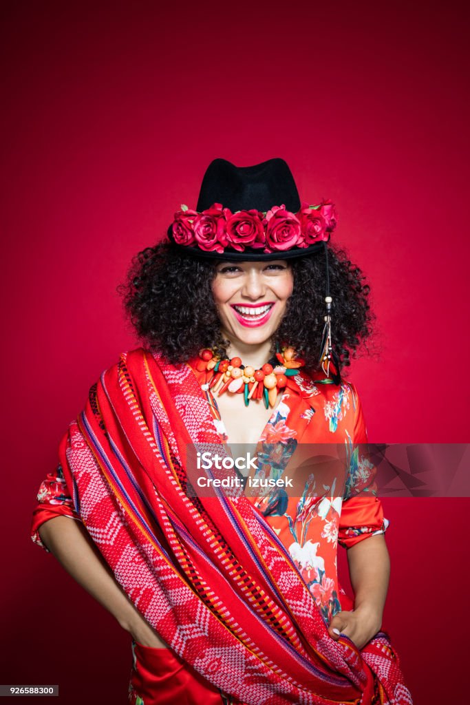 Fashion portrait of beautiful young woman in peruvian style Fashion portrait of beautiful young woman wearing red clothes and hat, standing against red background. Peruvian style. 20-24 Years Stock Photo