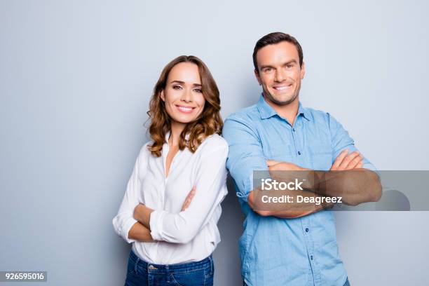 He Vs She Happy Together Close Up Portrait Of Attractive Caucasian Lovely Cute Adult Couple In Casual Outfit Looking At Camera Standing With Crossed Arms Over Grey Background Stock Photo - Download Image Now
