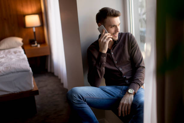 istock Young man with mobile phone in the room 926596782