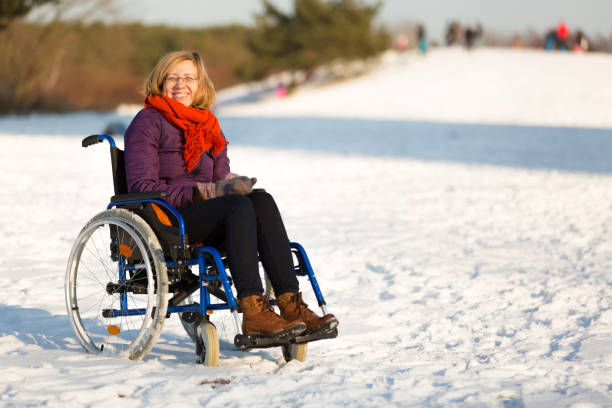 happy woman on wheelchair in the snow stock photo