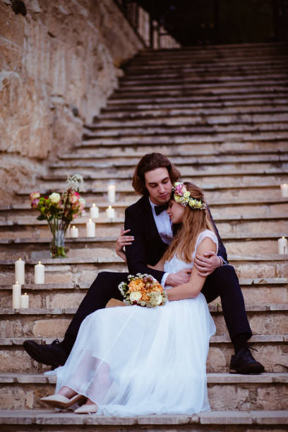 istock Newlywed bride and groom embracing and sitting on stone steps 926602946