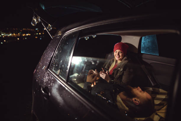 istock Young couple in love sitting in car open trunk 926605592