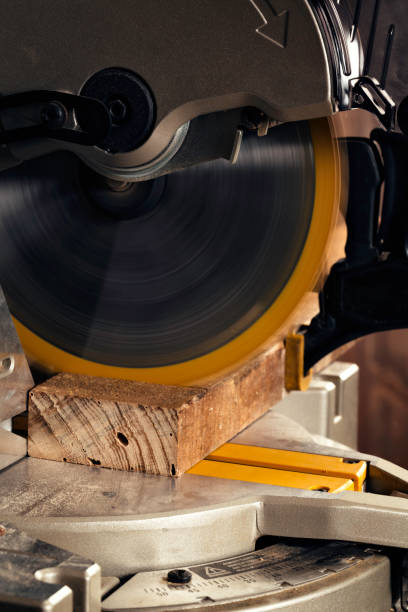 istock Close up of Single Bevel Compound Miter Saw in home workshop cutting lumber plank 926613448