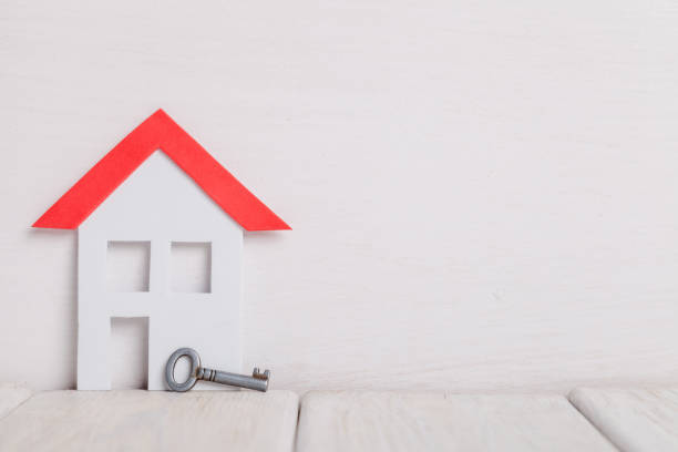 istock Small house with key over white wood an white background. 926613952