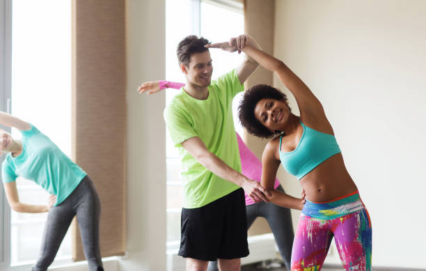 istock group of smiling people stretching in gym 926622060