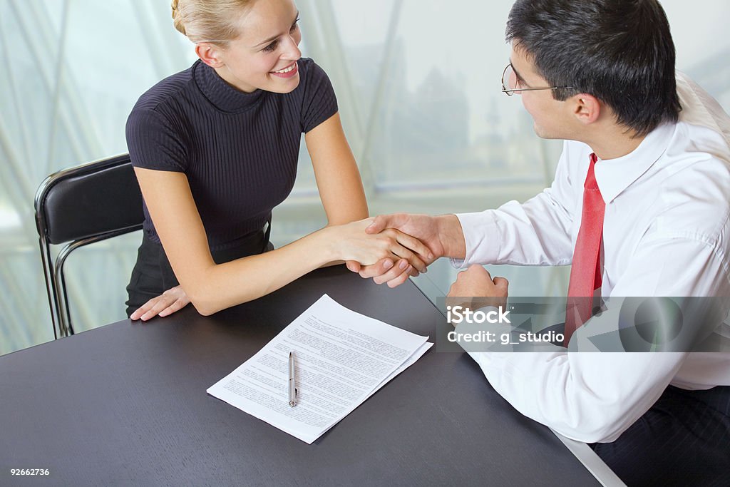 Uomo d'affari e donna d'affari stringe la mano in ufficio - Foto stock royalty-free di Accordo d'intesa