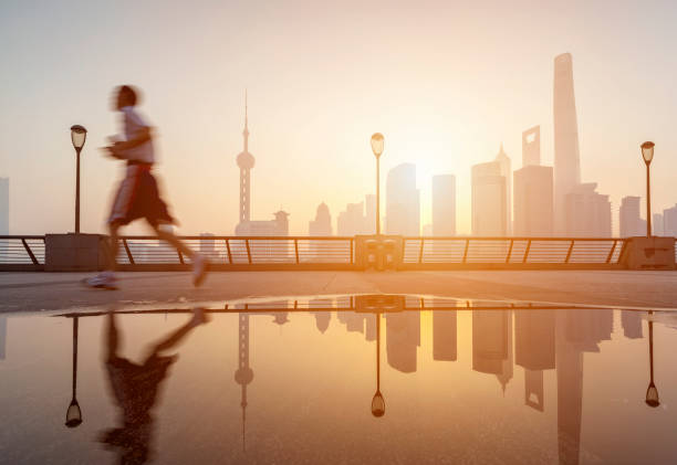 One young man running in the bund Low angle view of Shanghai Lujiazui Financial District in the morning. shanghai world financial center stock pictures, royalty-free photos & images