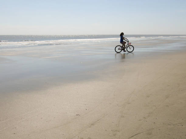 istock Retro Woman Riding Pink Bicycle on Beach 926629580