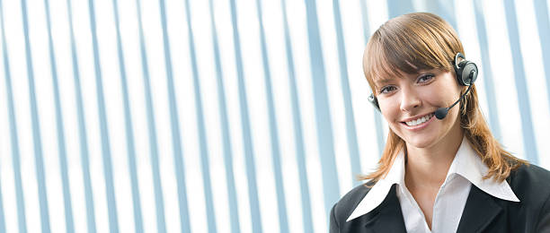 Young cheerful businesswoman with headset at office stock photo